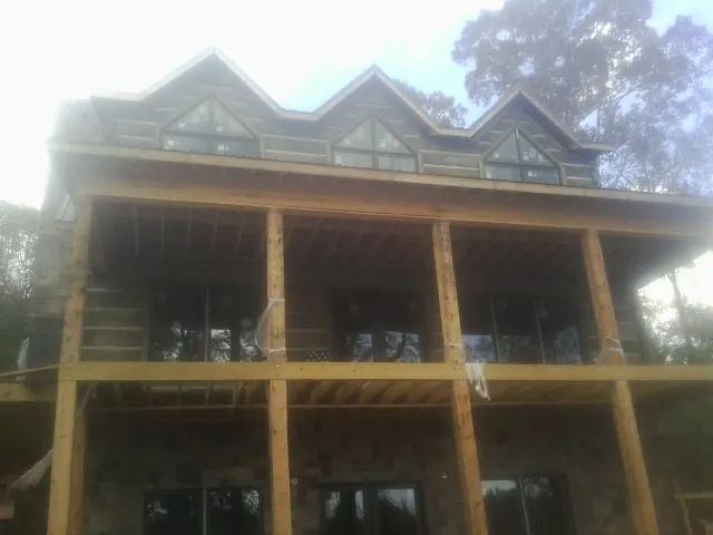 Dormers and porch framing on a large log home under construction — Roof Coating work by our crew in North Middletown