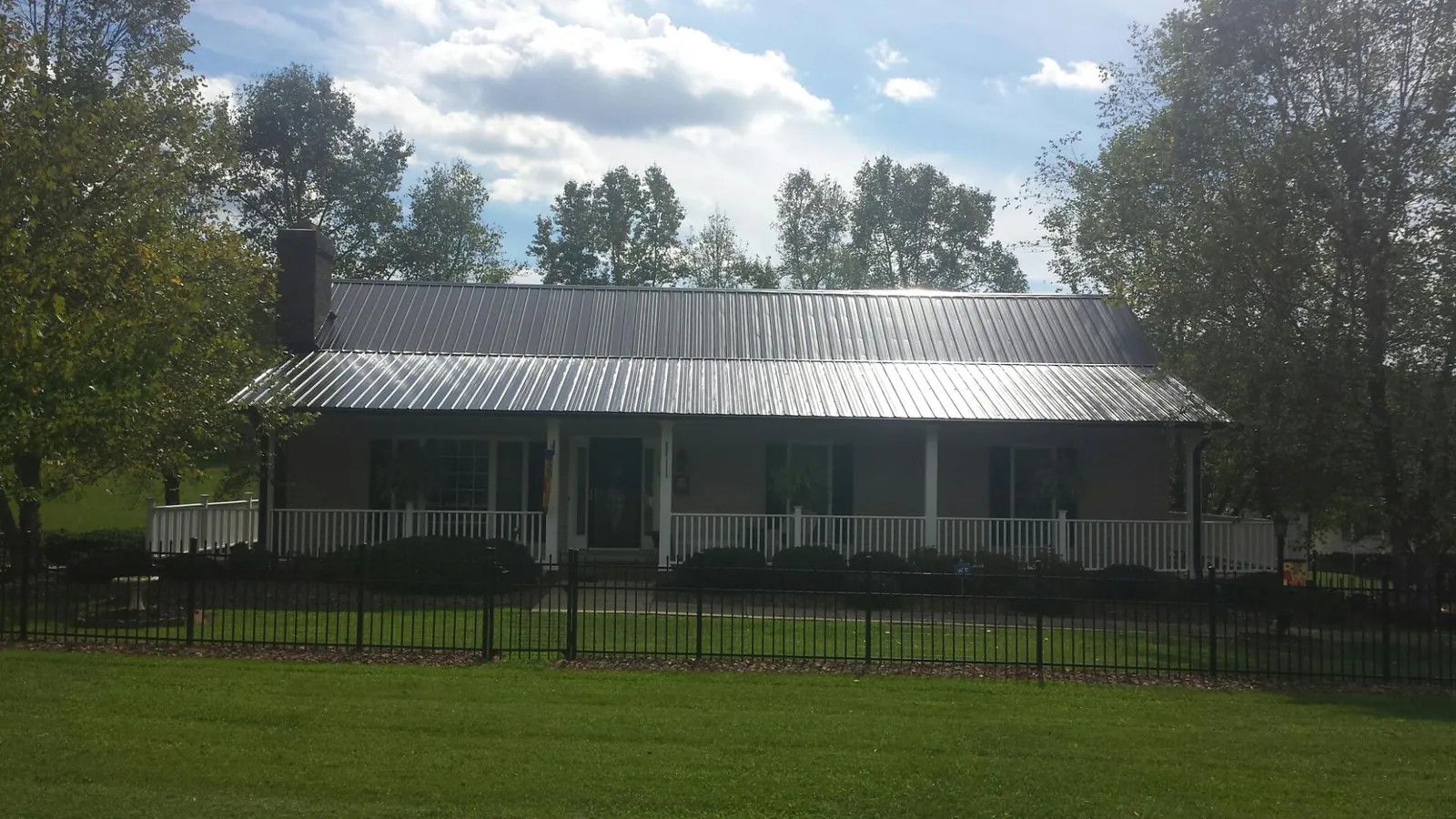Gray metal roof on a brick ranch with a full width front porch — Gutter Guard Installation work by our crew in North Middletown